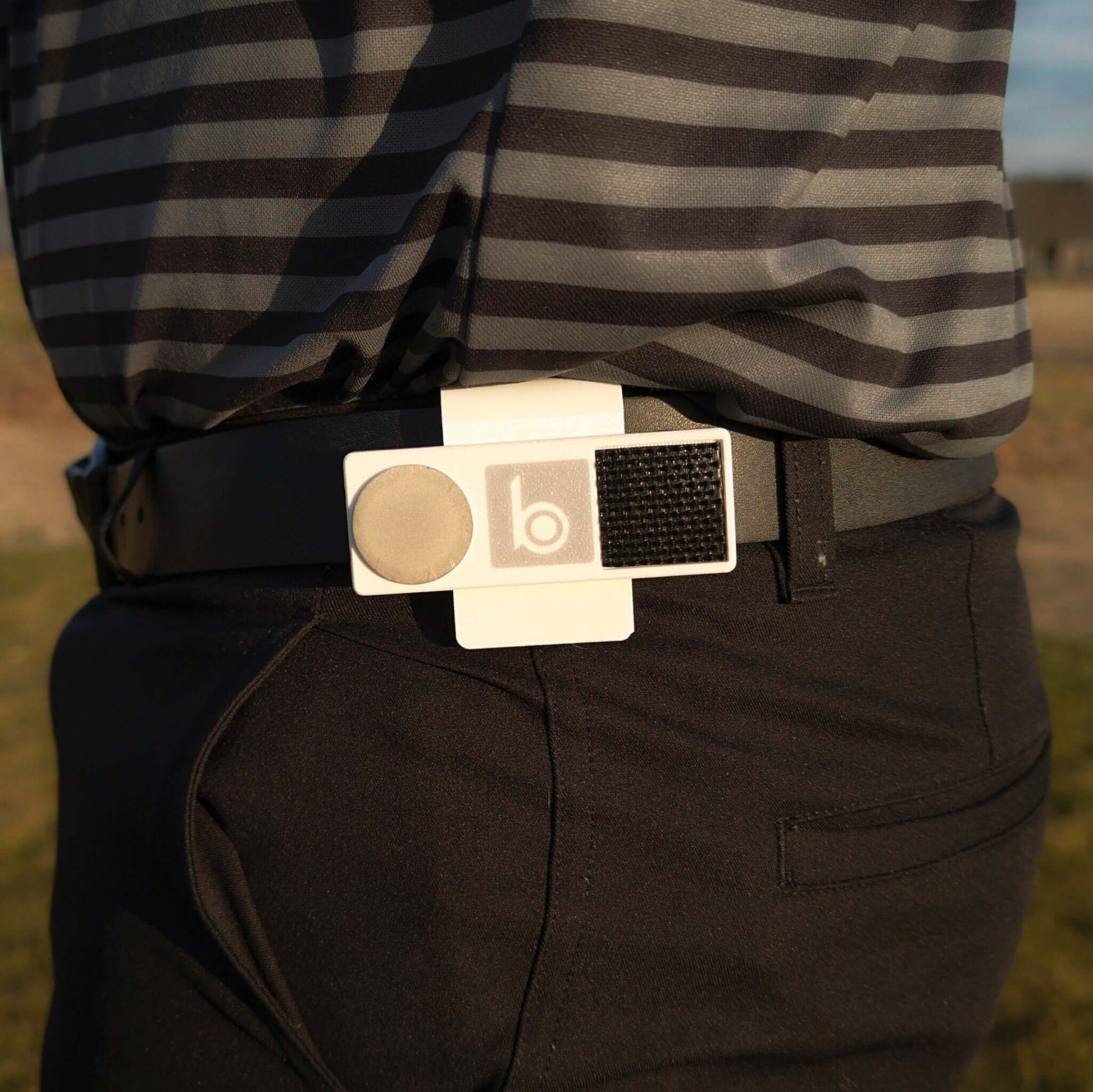 ProtoClip MINI 1 attached to a golfer's belt, showcasing its sleek and lightweight design for easy access.